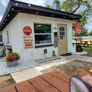 The front. There are picnic tables set up with umbrellas and hand wash stations.