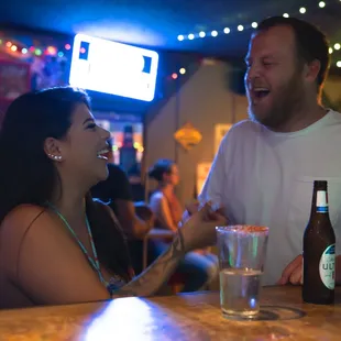 a man and a woman sitting at a bar
