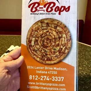 a hand holding a box of pizza