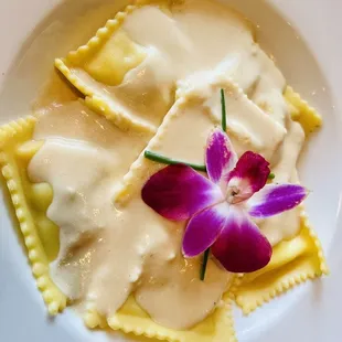 a plate of ravioli with a flower