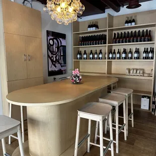 a bar with stools and bottles of wine