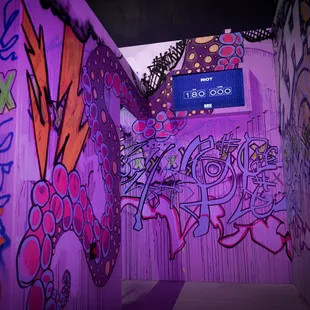 a purple wall with graffiti on it