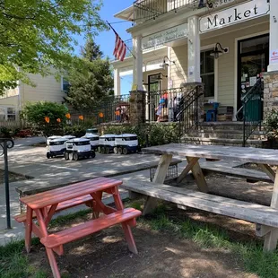 a red picnic table in front of a store
