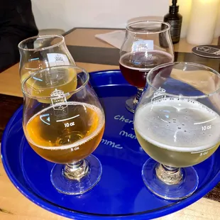 three glasses of beer on a blue tray
