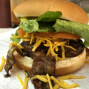 Broaddus burgers on a white bun with bacon and cheddar cheese.