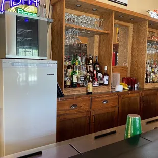 a bar with a refrigerator and bar stools