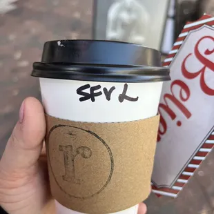 a hand holding a cup of coffee