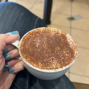 a woman holding a cup of coffee