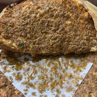 a hand holding a piece of pizza