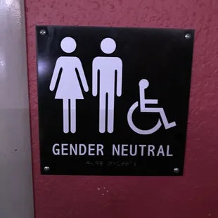 a restroom sign with a man and a woman in a wheelchair