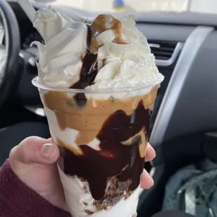 a hand holding a cup of ice cream