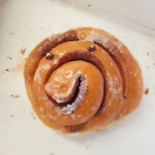 a cinnamon roll with powdered sugar on top