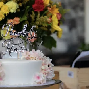 a wedding cake with flowers in the background