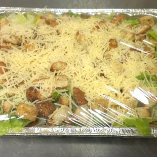 Our freshly made caesar salad for catering, topped with homemade croutons and shredded parmesean cheese
