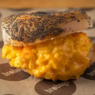 a bagel sandwich with cheese and black sesame seeds