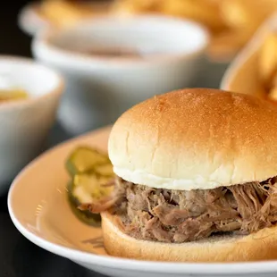a pulled pork sandwich and chips
