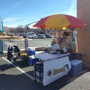 a hot dog stand with an umbrella