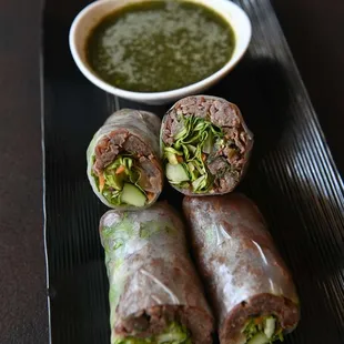 a plate of rolls with dipping sauce