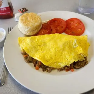 Gyro Omelette with three brown eggs, Gyro meat, onions, tomatoes and Feta cheese served with tzatziki sauce, grilled tomatoes and a biscuit.