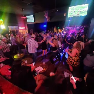 a crowd of people dancing and drinking