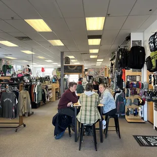 two men sitting at a table in a clothing store