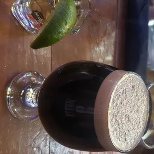 a glass of alcohol and a lime