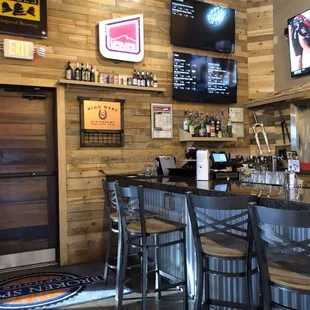 a bar with chairs and a television