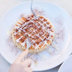 a person cutting into a waffle