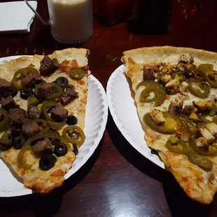 two slices of pizza on paper plates