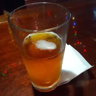 a glass of beer on a napkin