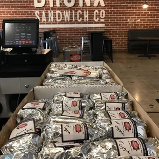 Hot sandwiches foiled wrapped in half for catering.