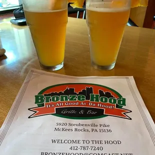 two glasses of beer and a menu