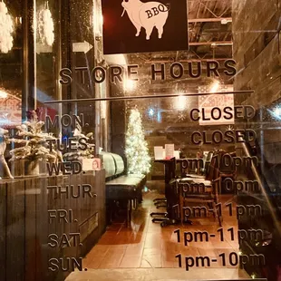 Restaurant entrance door with hours of operation.