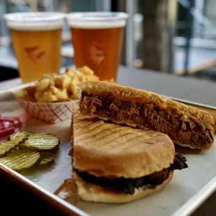 a sandwich and pickles on a tray