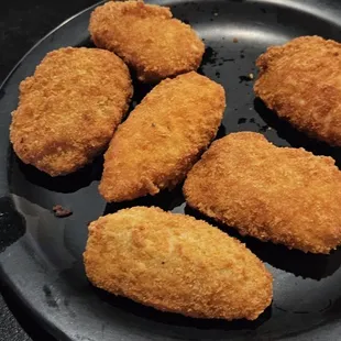 fried chicken nuggies on a black plate