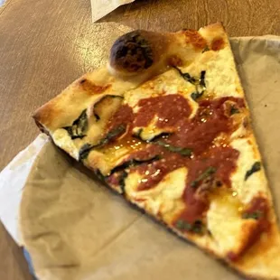 a slice of pizza on a paper plate