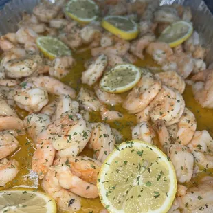 a pan of shrimp and lemons