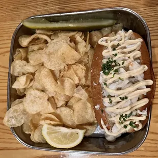 a hot dog, chips, and pickle