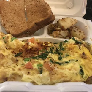 an omelet, toast, and potatoes in a styrofoam container