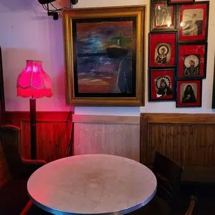 a table and chairs in front of a painting