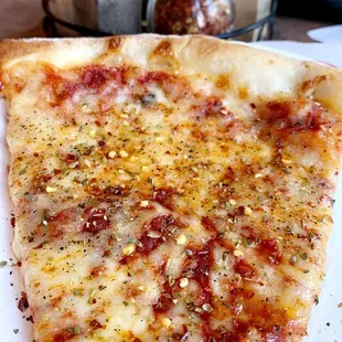 cheese pizza sprinkled with red pepper flakes &amp; oregano
