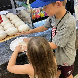 a boy and a girl making doughnuts