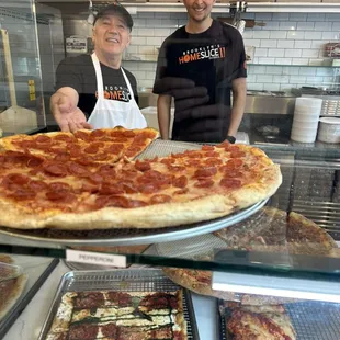 One of pizza and counter guys in front of one of our staple pepperoni pizza