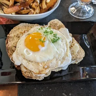 Bacon and Swiss cheese between tangy sourdough bread, topped with a runny fried egg and maple mustard /  bechamel sauces.