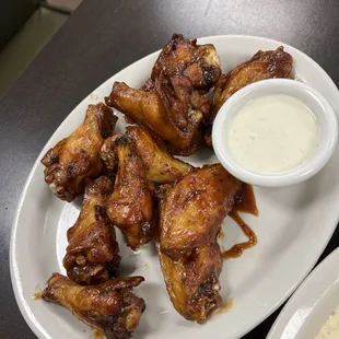 a plate of chicken wings and a side of mashed potatoes