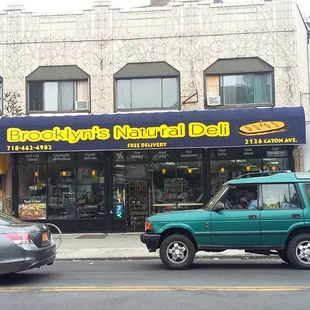 a green car parked in front of a store