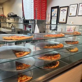 Pizza by the slice a bunch of different flavors