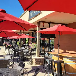 tables and chairs with red umbrellas
