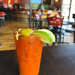 a bloody drink with a lime garnish