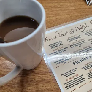 a menu and a cup of coffee